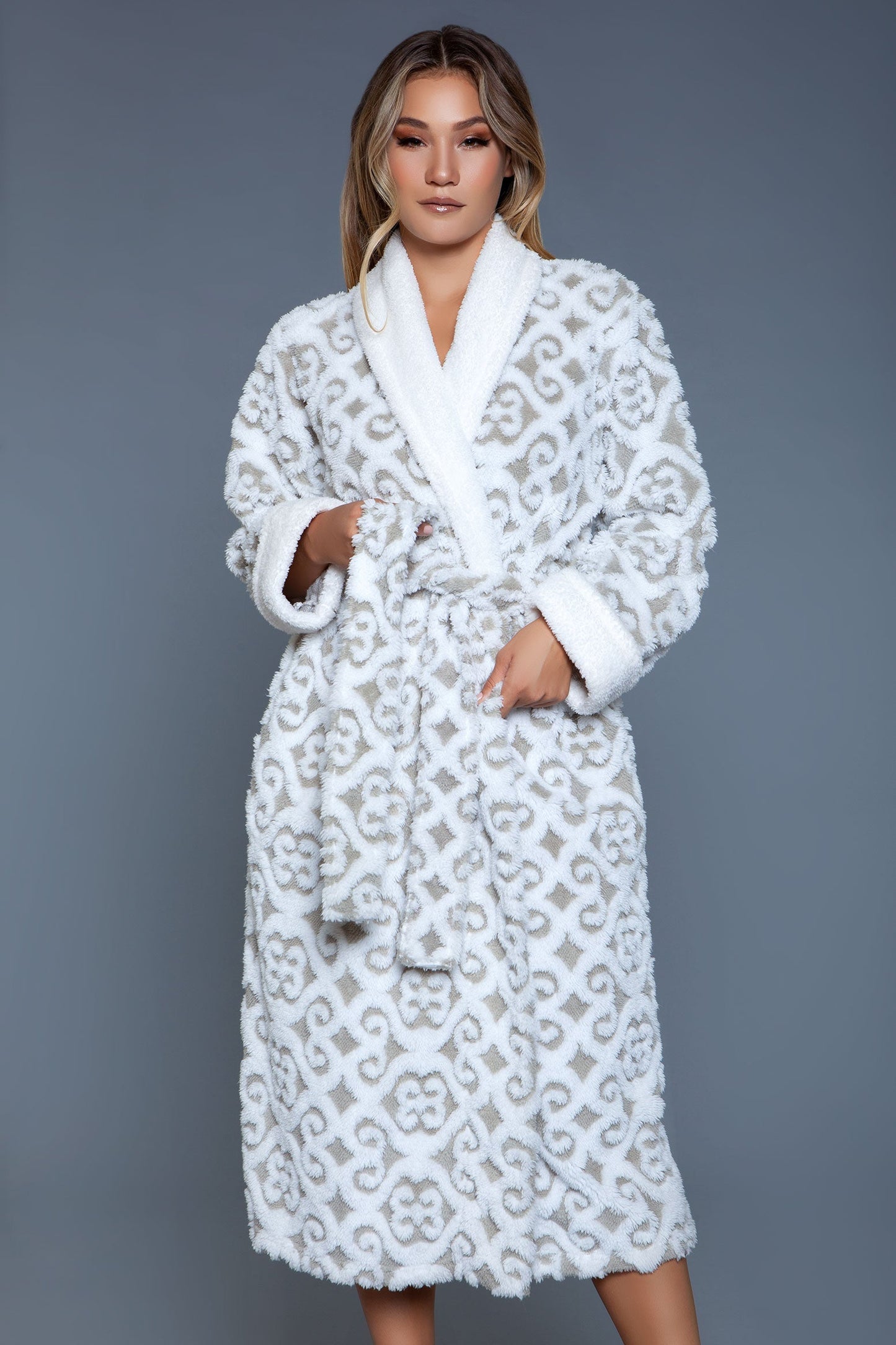 The Kimmie Robe is a luxurious fusion of style and comfort, crafted from ultra-soft sherpa fabric adorned with a modern damask pattern. This robe is designed to provide warmth and coziness without compromising on elegance, making it a perfect choice for those leisurely days at home or relaxing evenings. Solid collar and cuffs Long sleeves Matching front tie belt