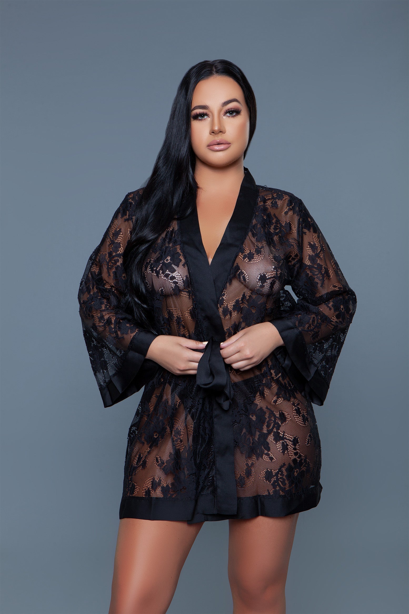 The Delia Robe with satin trim is a beautifully crafted piece that epitomizes elegance and femininity. This exquisite robe features a floral lace body that offers a peek of what's beneath, finished with smooth satin trim along the edges, including the cuffs, front opening, and hemline providing a perfect blend of allure and sophistication. Open front 3/4 Sleeves Matching front tie satin belt Thong not included