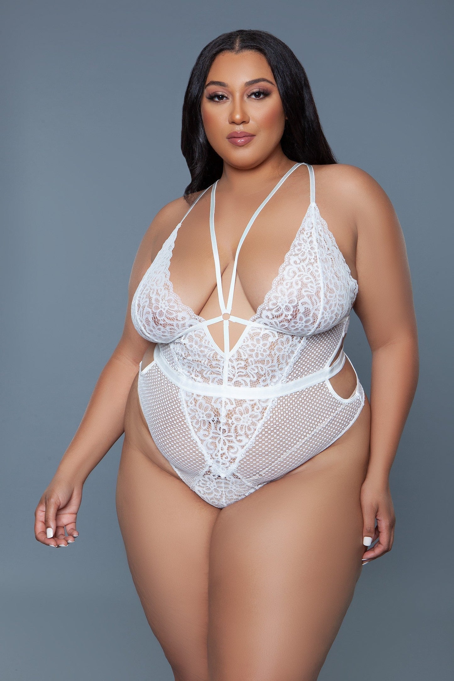 A Classic Elise Bodysuit With A Sexy Twist. Floral and dot mesh contrast Side waist cut-out detail Deep plunge V neckline Strappy front detail Back adjustable crisscross back Back hook and eye keyhole closure Stretchy material that hugs the silhouette Open crotch bottom Made in China